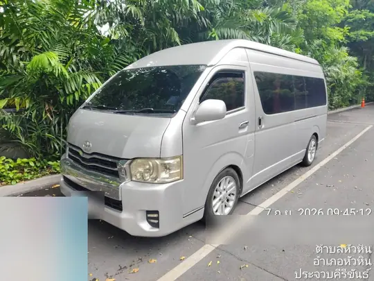 รถตู้ Toyota Commuter สีเงินจอดรอลูกค้าท่ามกลางต้นไม้ที่หัวหิน