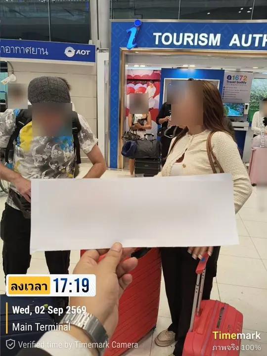 คนขับถือป้ายรับผู้โดยสาร ข้างเคาน์เตอร์ข้อมูลท่องเที่ยวในอาคารขาเข้า สนามบินสุวรรณภูมิ