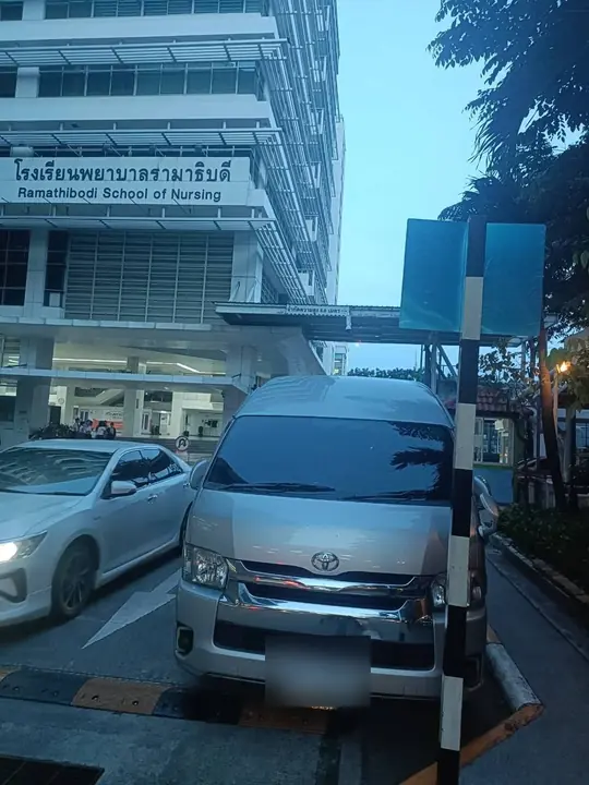 รถตู้ Toyota Commuter สีเงินจอดรอรับลูกค้าหน้าอาคารรามาธิบดี กรุงเทพฯ